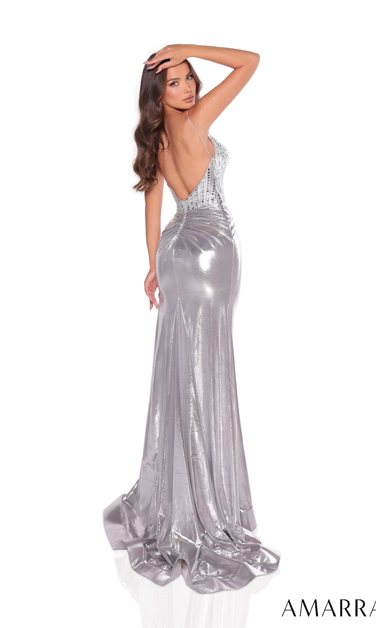 A woman poses against a white background in the Amarra 88212 long silver prom dress, featuring a metallic finish, beaded bodice with thin straps, and a dramatic high leg slit.